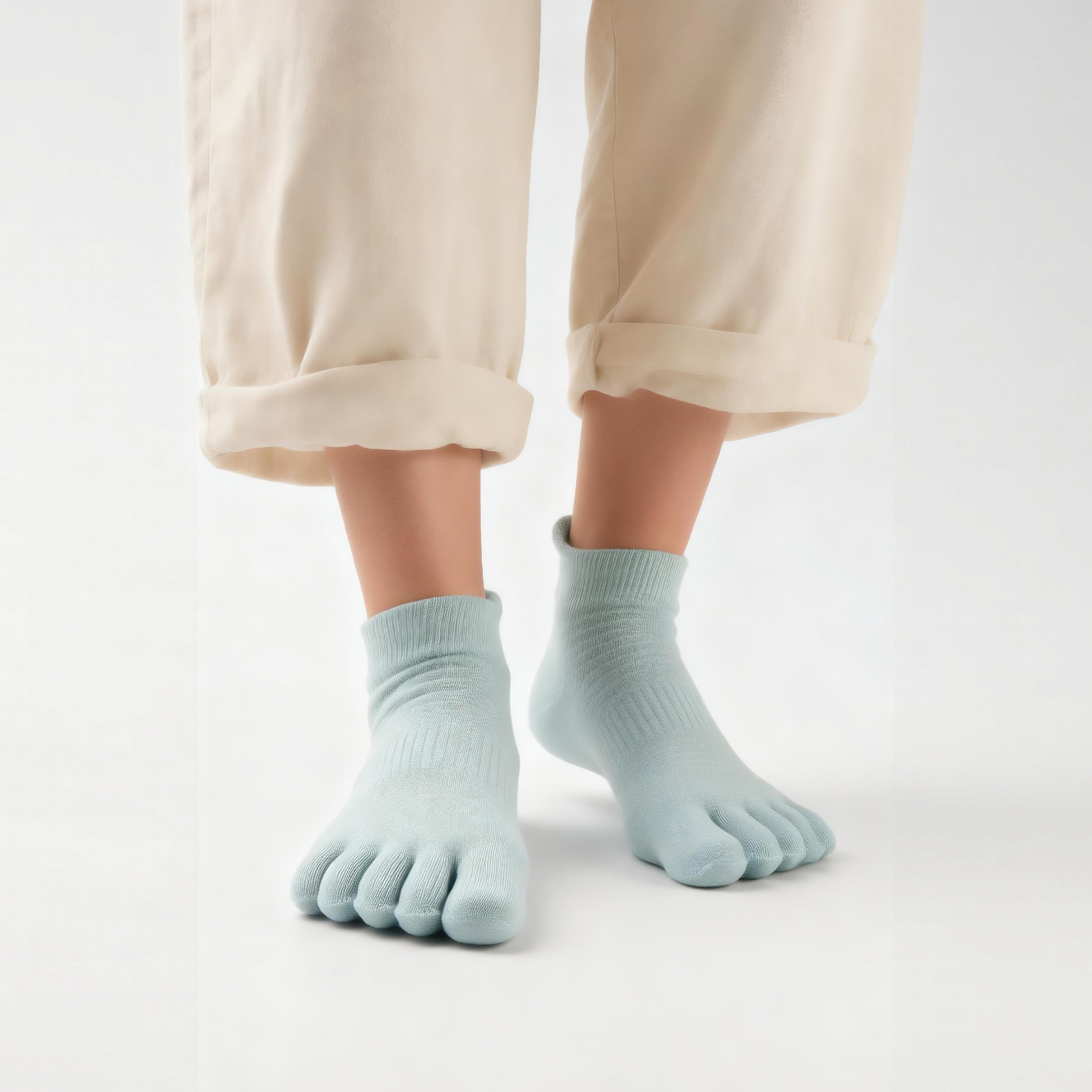 Light blue toe socks worn with beige pants on a white background