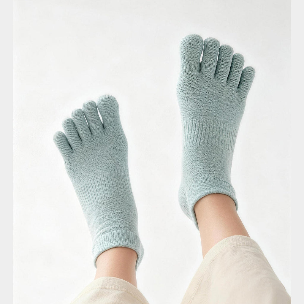 Light blue socks with toe separation worn by a person on a white background