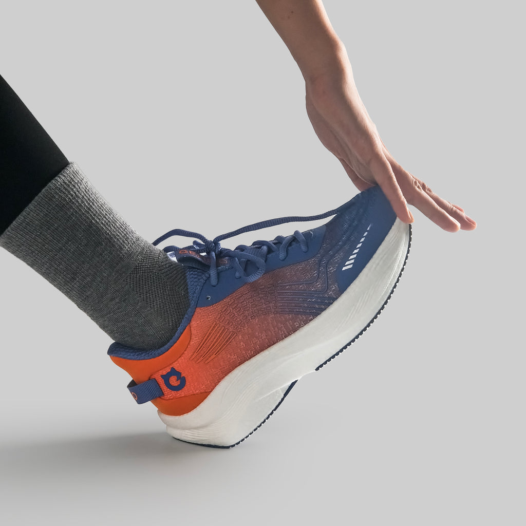 Person wearing a blue and orange EFISIO Airfoil II Athletic Shoe on a light gray background