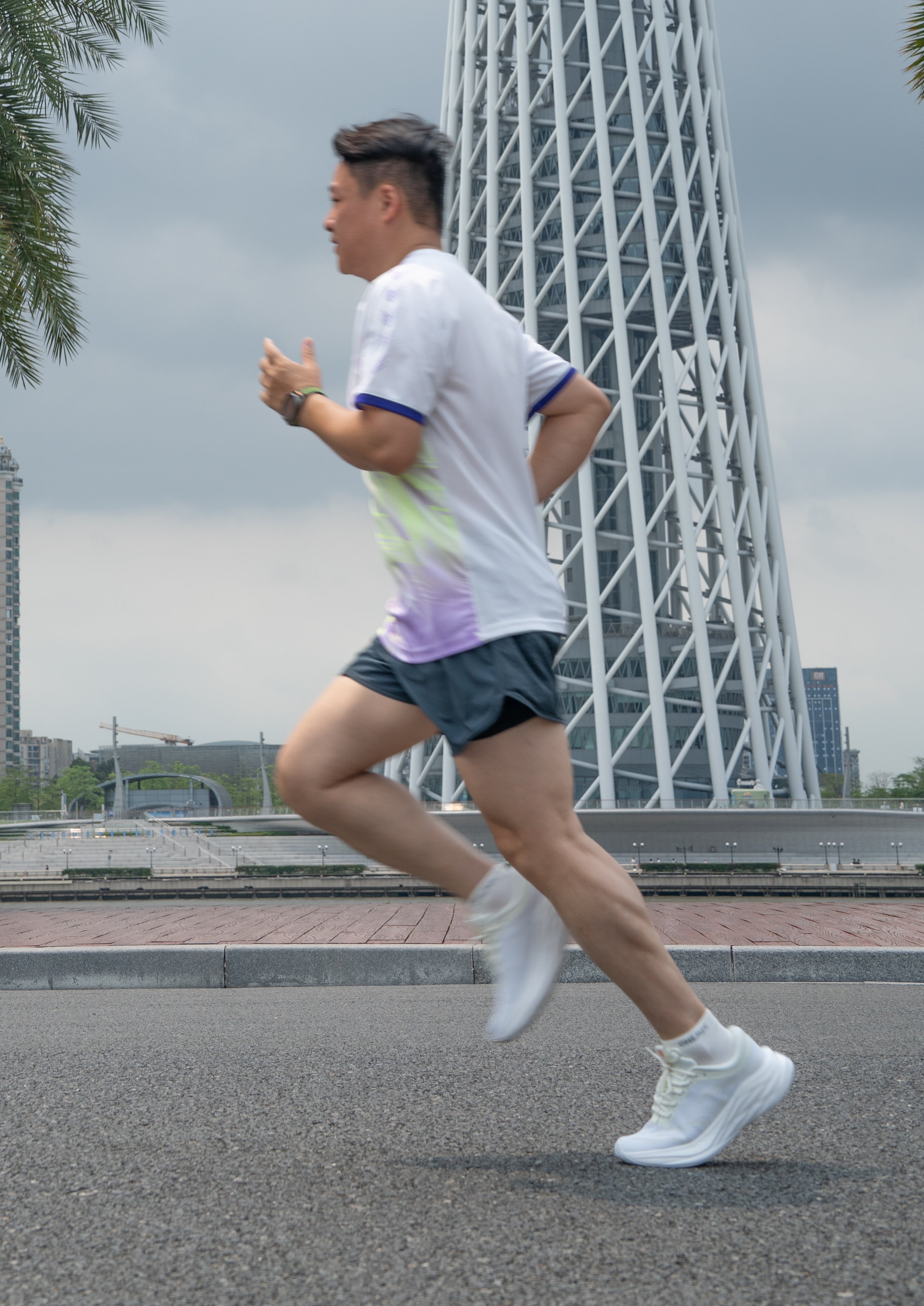 Runner wearing EFISIO Airheart athletic shoes on the road with the iconic Canton Tower in the background