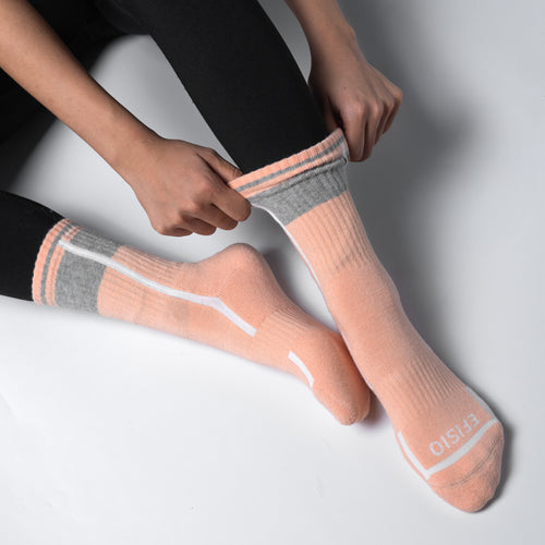 Person wearing pink EFISIO All-Day Running Socks socks with gray accents on a light gray background