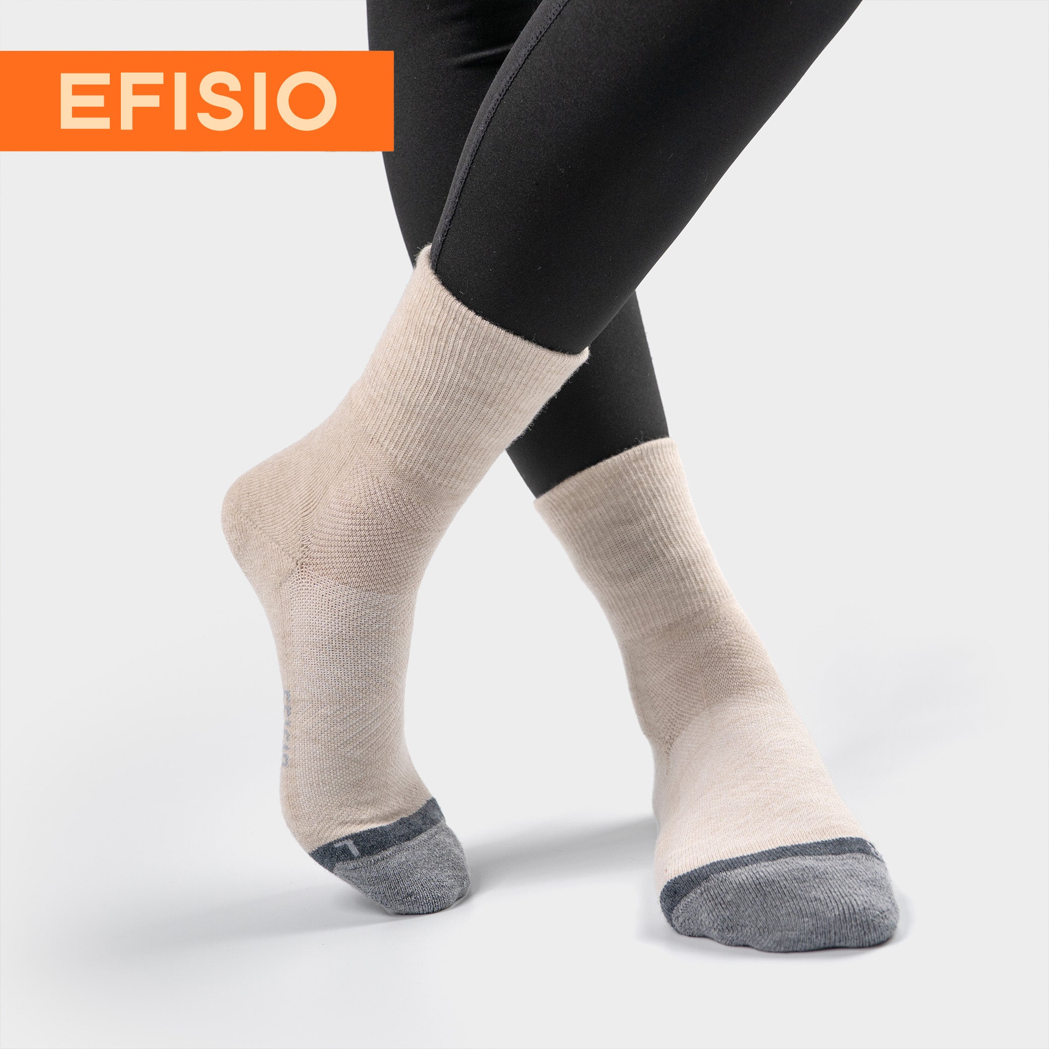 Close-up of a model wearing black leggings and EFISIO Merino Wool Crew Socks with legs crossed, on a white background