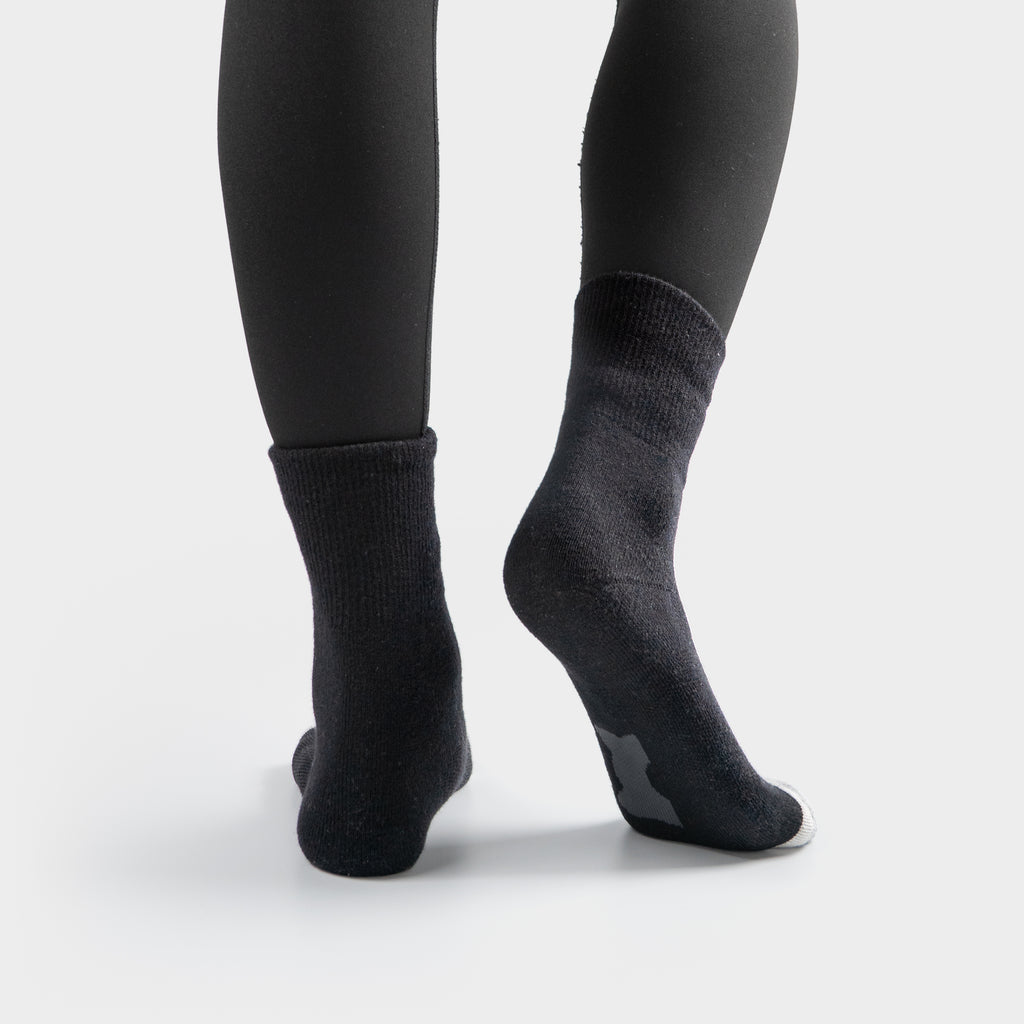 Black EFISIO Merino Wool Crew socks worn with black leggings on a white background