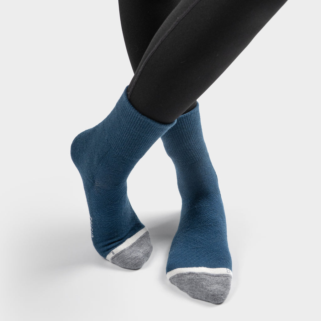 Blue EFISIO Merino Wool Crew socks with gray toes worn with black leggings on a white background