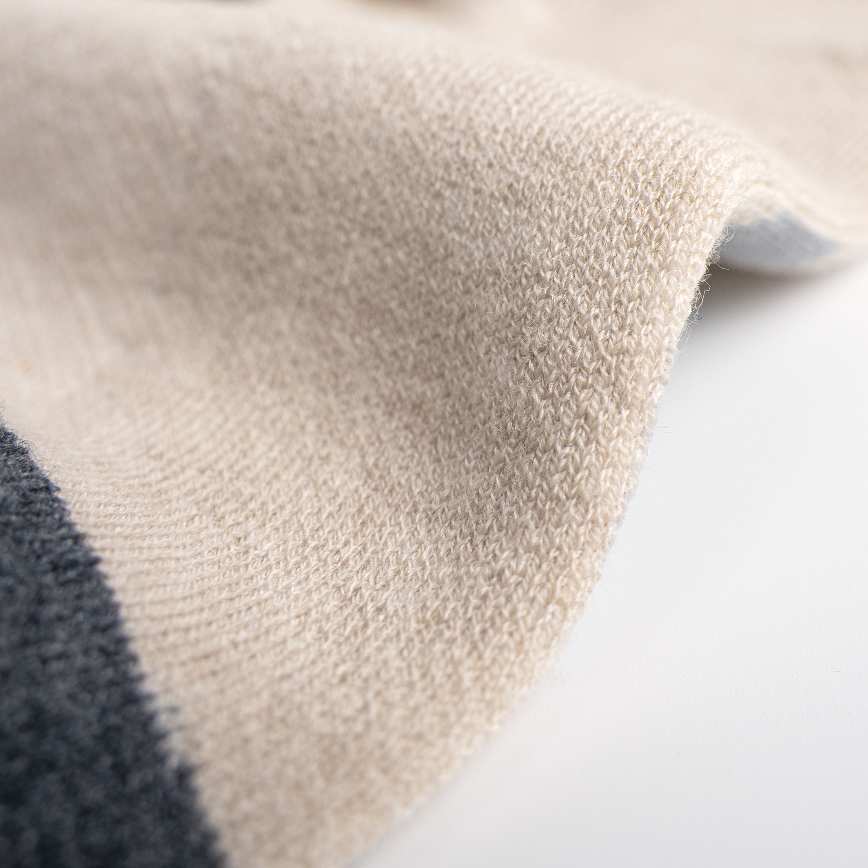 Close-up of EFISIO Merino Wool Crew textured beige fabric on a light background
