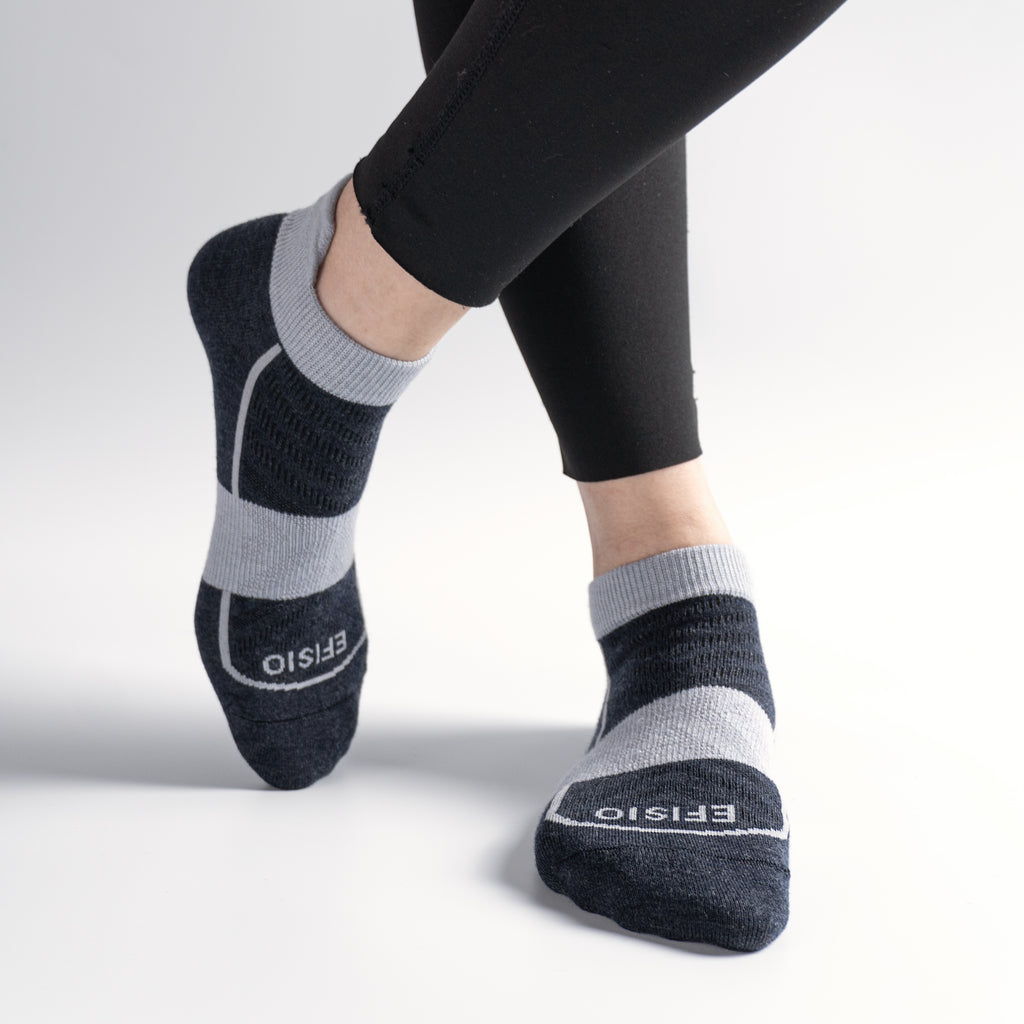 Person wearing black and gray EFISIO Merino Wool Tab socks with 'EFISIO' branding on a light gray background
