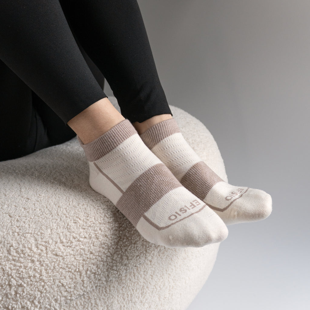 Person wearing light gray EFISIO Merino Wool Tab ankle socks with brown stripes on a neutral background