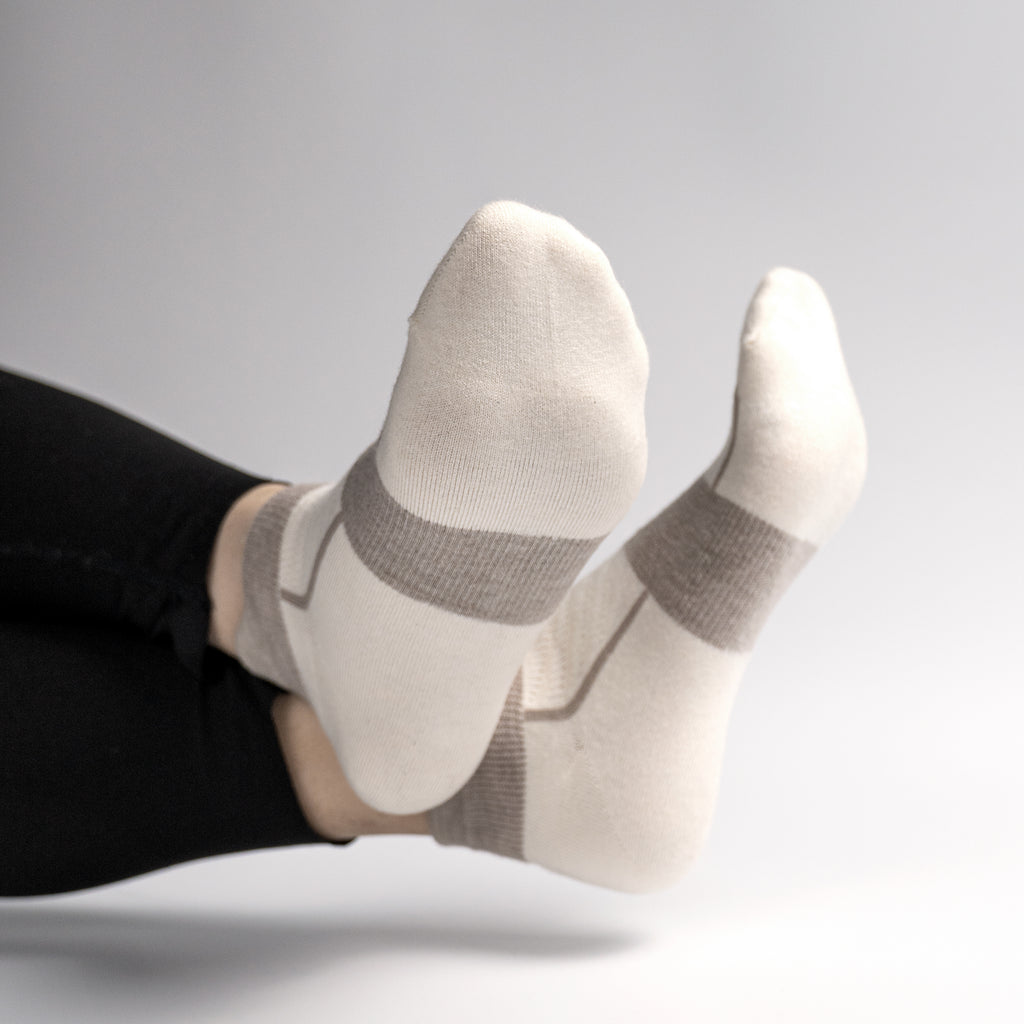 White EFISIO Merino Wool Tab socks with gray accents worn by a person on a light gray background