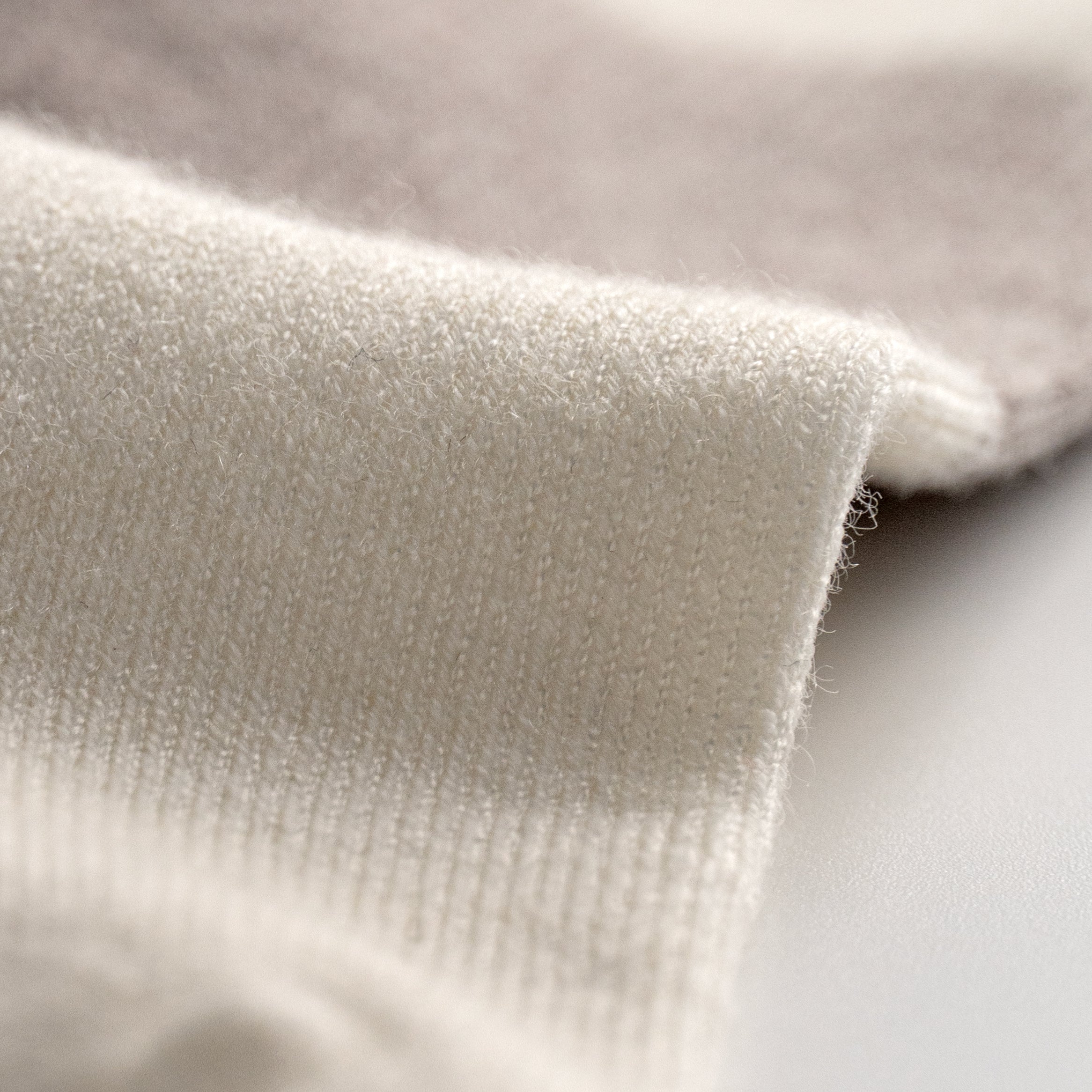 Close-up of EFISIO Merino Wool Tab textured beige fabric on a neutral background