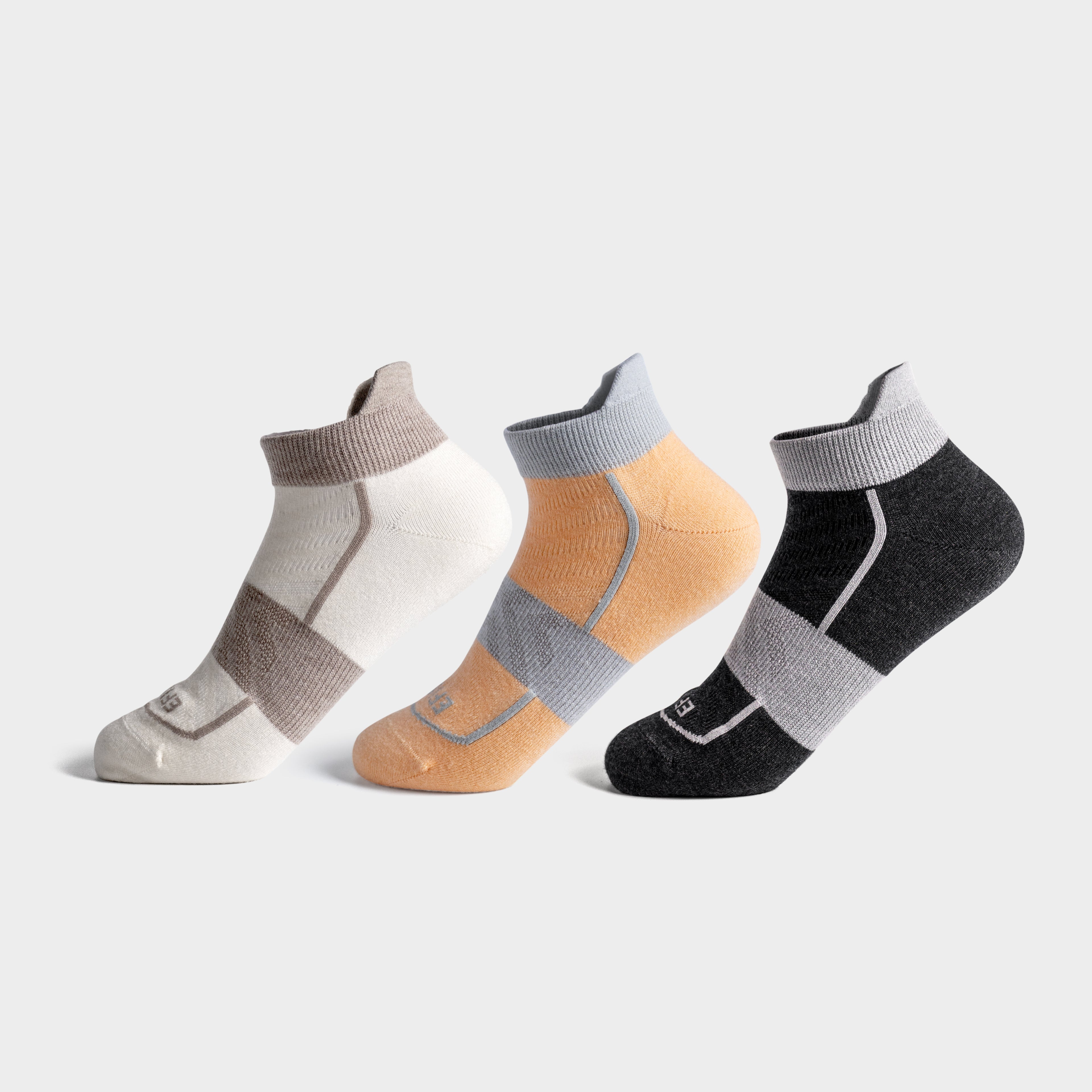 Three pairs of EFISIO Merino Wool Tab socks in beige, pink, and black on a light gray background